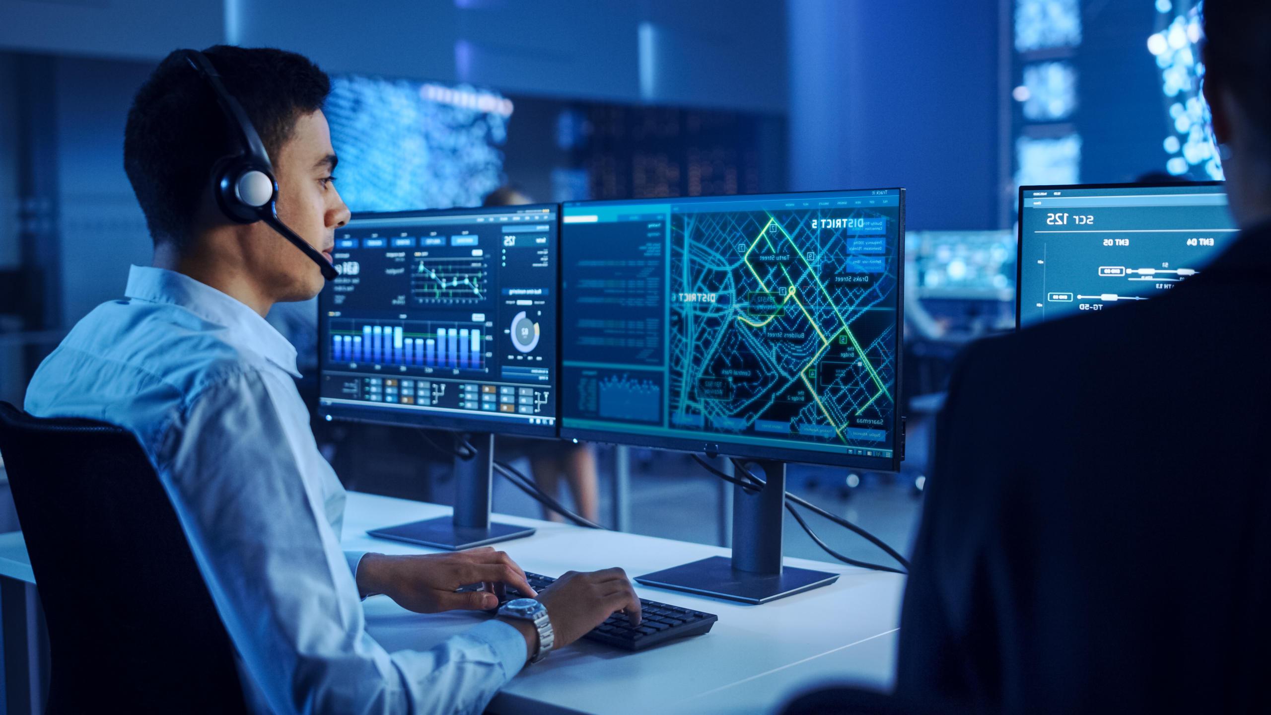 Man working in IT on multiple computer screens