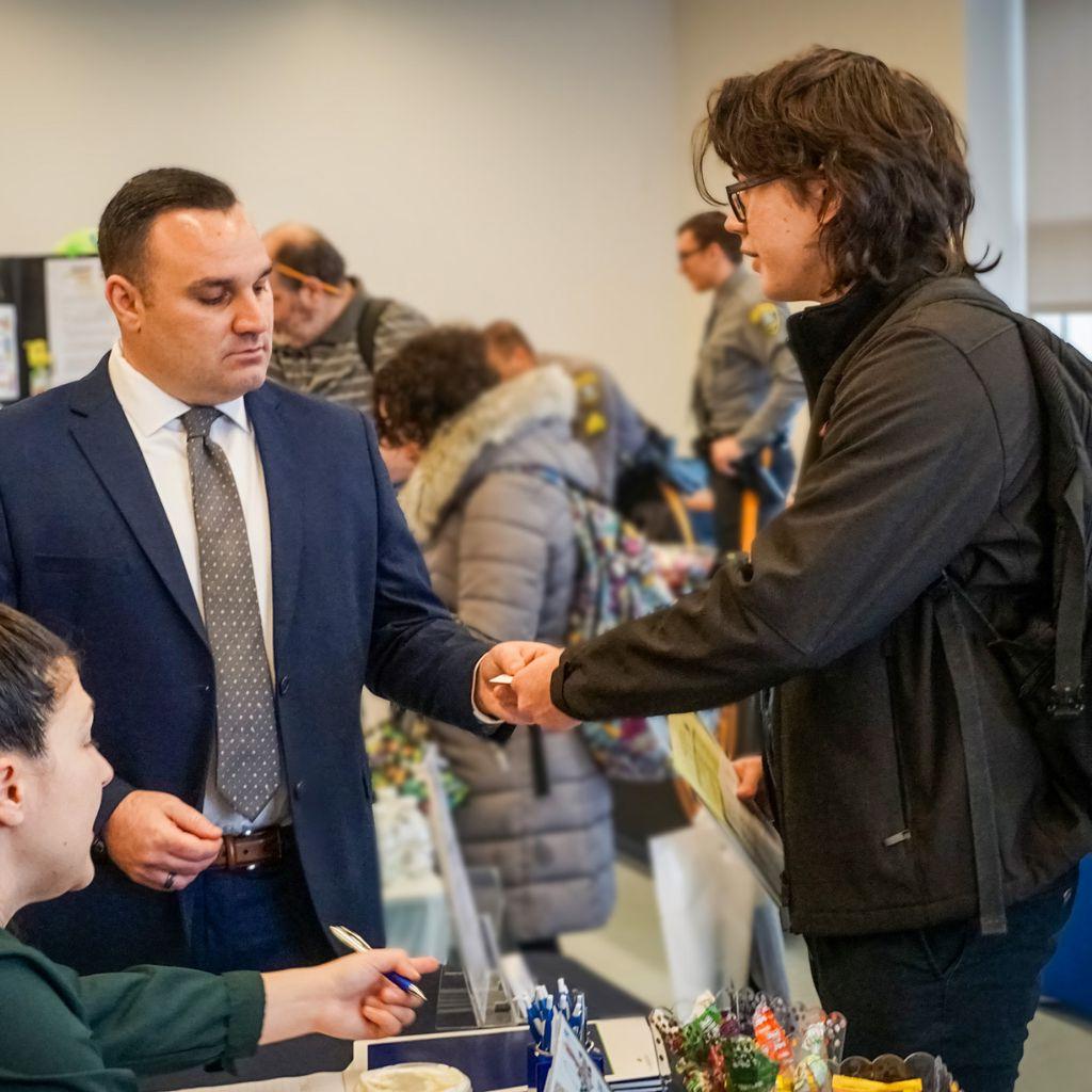 A student shaking hands with a man at a student event