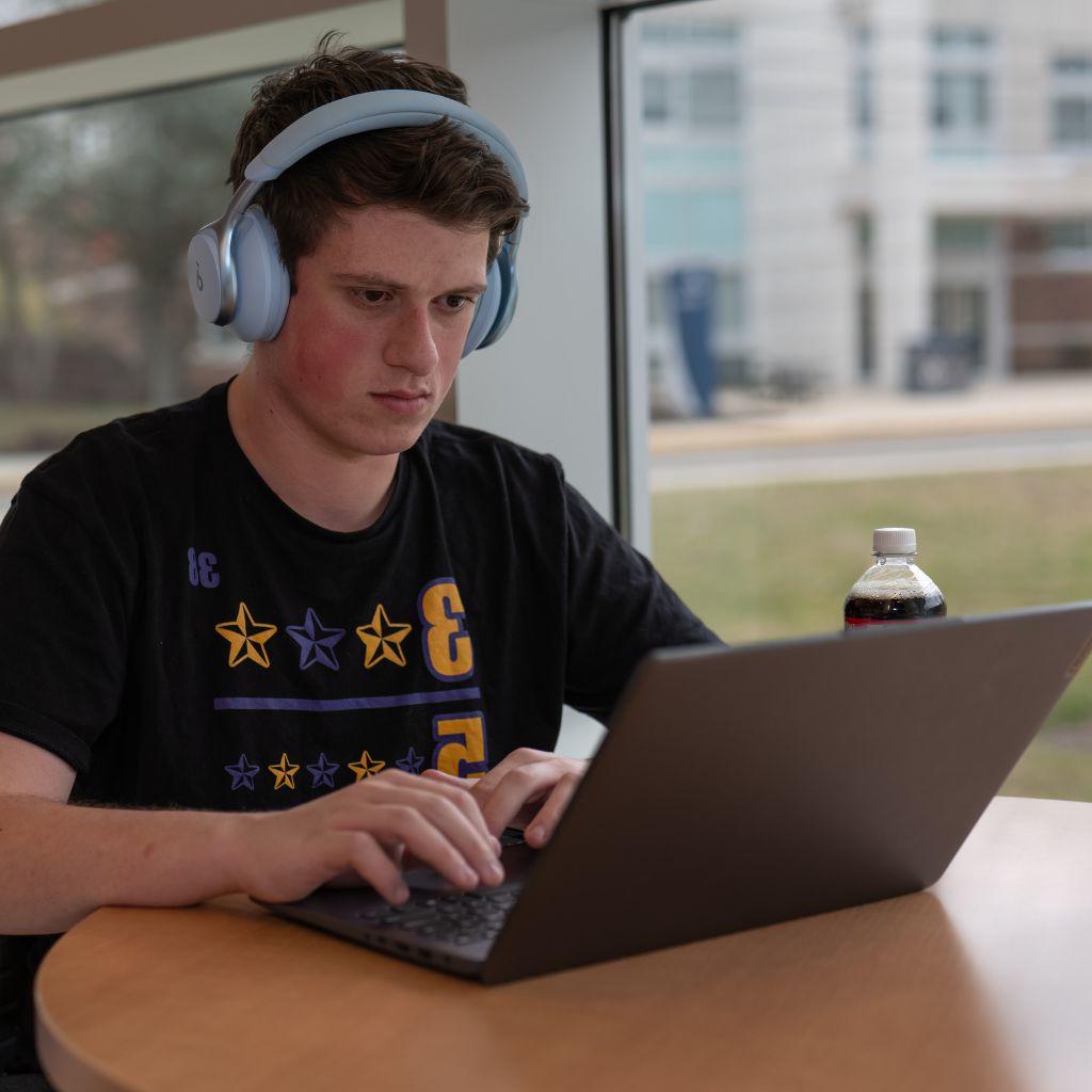 Student sitting at desk working on laptop